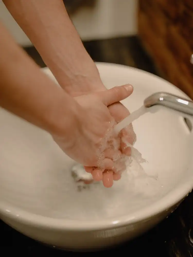 What Causes Low Water Flow in Faucets and How to Fix It: A Guide for Homeowners 1 一個人使用洗面盤水龍頭