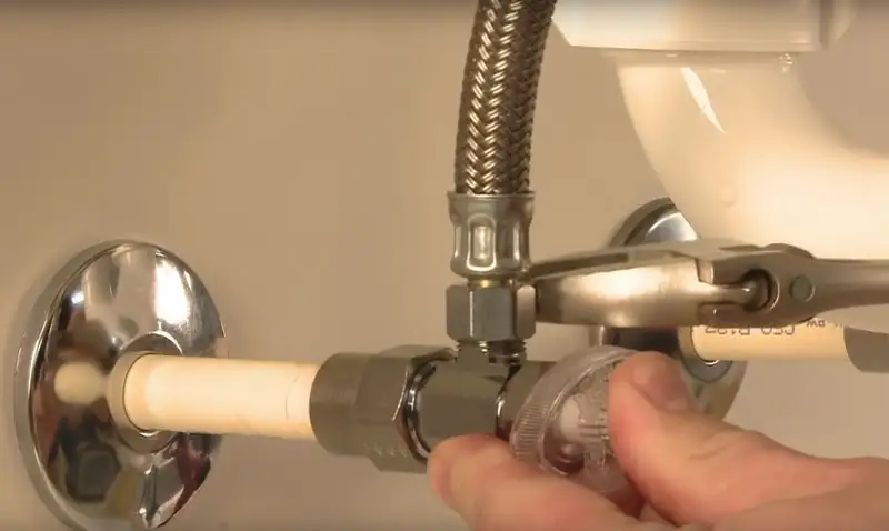 廁所鹹水掣故障?一文教你如何應對 1 cover of the article with a hand fixing a angle valve